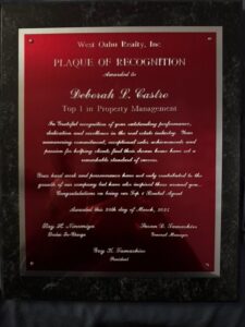 Plaque recognizing Deborah L. Castro as Top 1 in Property Management for outstanding performance at West Oahu Realty, Inc., awarded March 26, 2023.